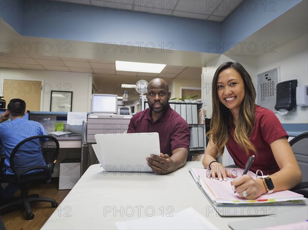 Portrait of smiling nurses with binders and hospital