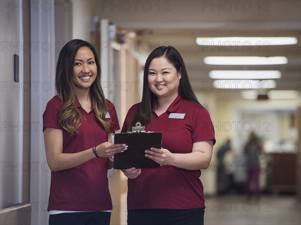 Smiling nurses holding clipboard in hospital