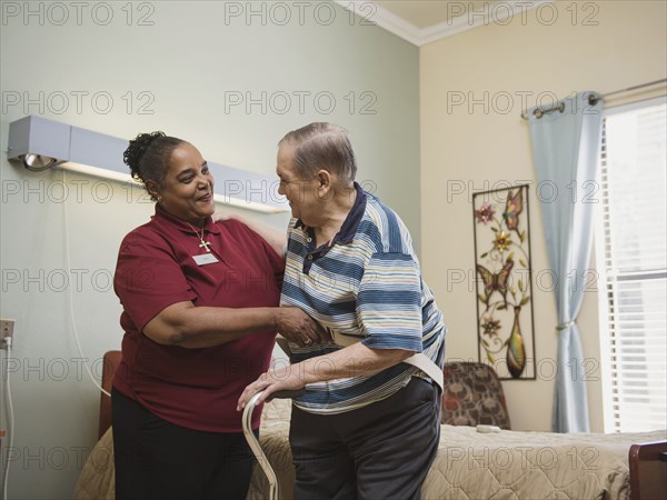 Nurse helping man using cane