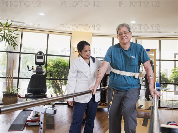 Physical therapist helping walking man