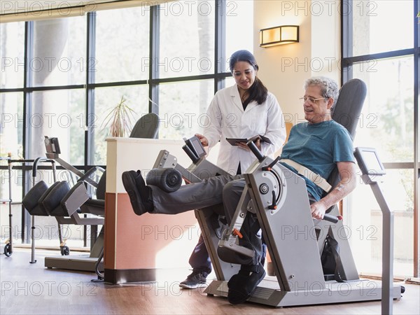 Physical therapist helping man strengthen legs