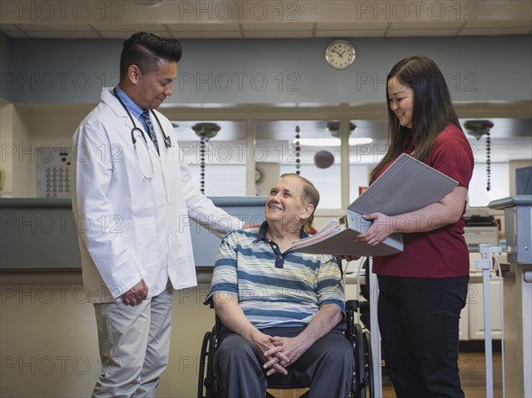 Doctor comforting patient in wheelchair