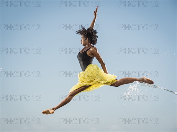 Water spraying on black woman ballet dancing