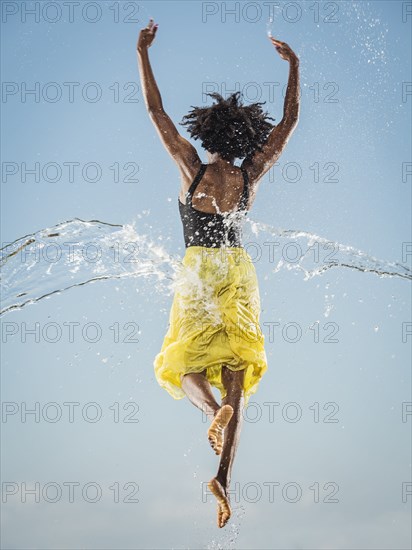 Water spraying on black woman ballet dancing