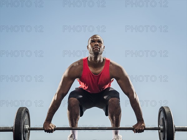 Black man preparing for lifting barbell