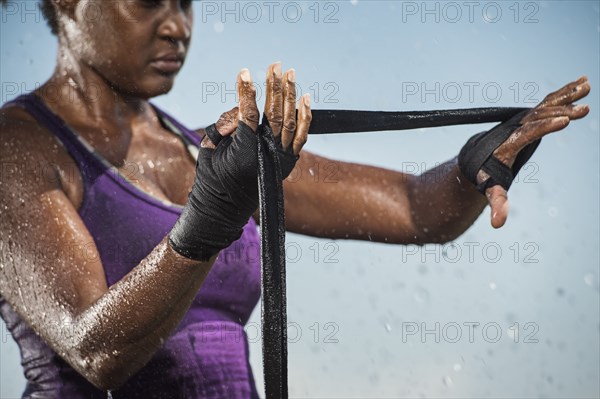 Black woman wrapping hands for boxing