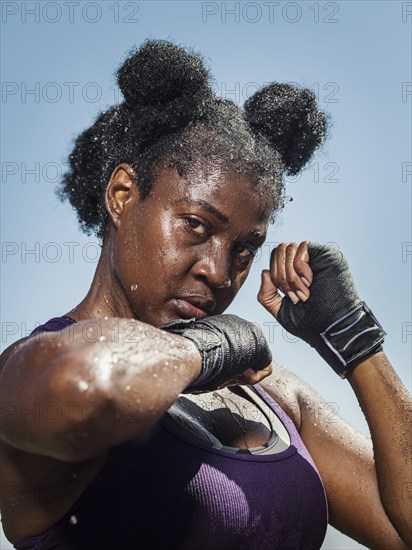 Portrait of black woman with hands wrapped for boxing