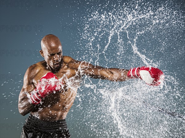 Water splashing on black boxer punching