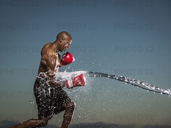 Water splashing on black boxer punching