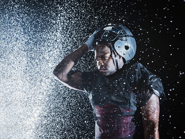 Water splashing on black football player