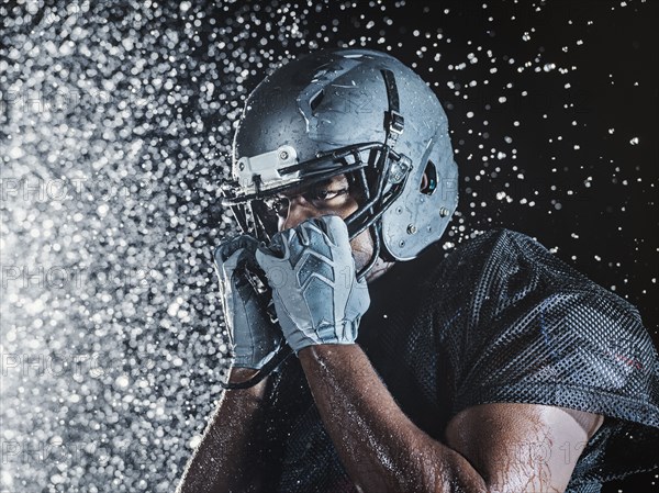 Water splashing on black football player