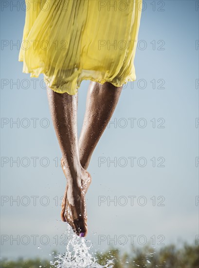 Feet of Black dancing jumping in water