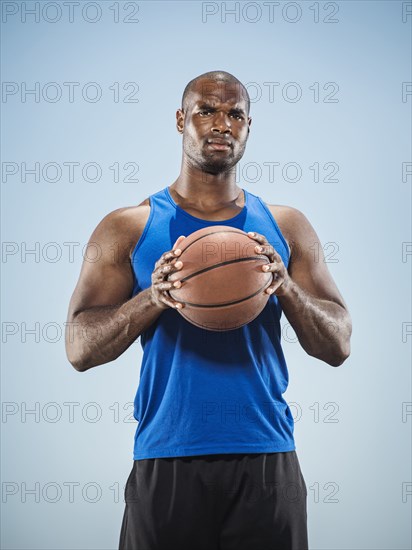 Portrait of serious Black man holding basketball