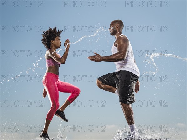 Water splashing on running Black couple