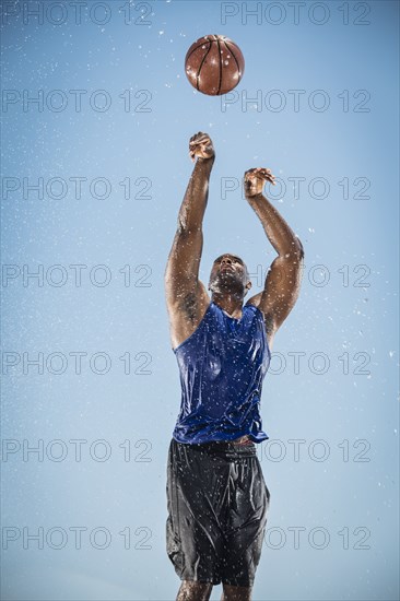 Water splashing on Black man shooting basketball