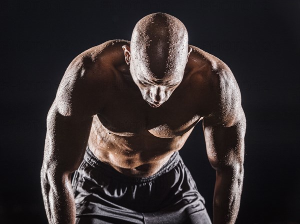 Sweating Black man bending and resting