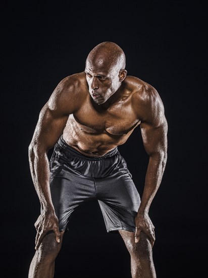 Sweating Black man bending and resting