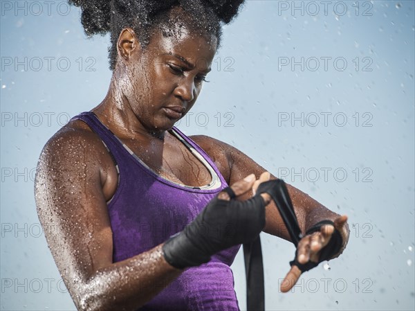 Sweating Black boxer wrapping hands