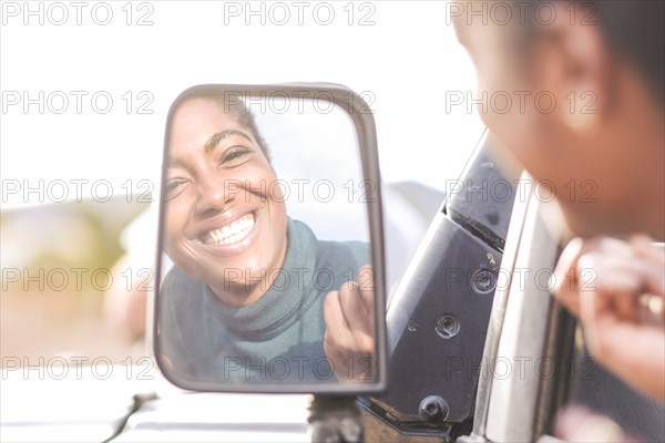 Reflection of African American woman in car mirror