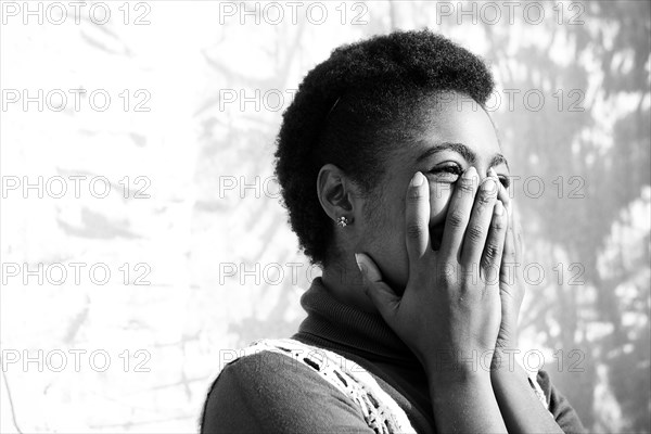 Laughing African American woman with hands on face