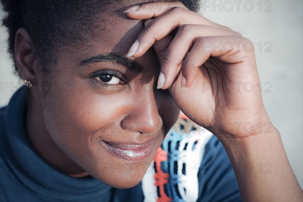 Smiling African American woman with hand on forehead