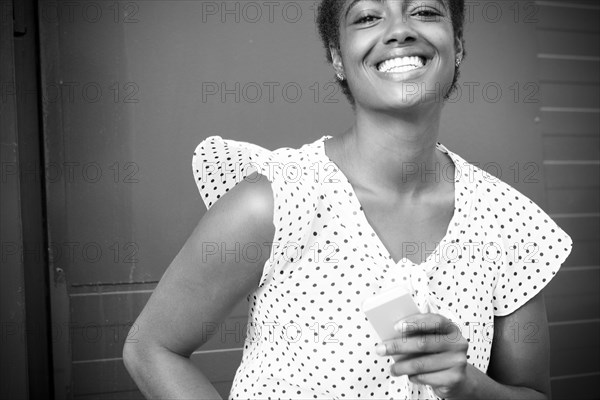 Smiling African American woman holding cell phone