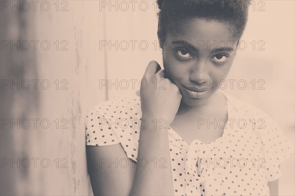 Smiling African American woman leaning on wall