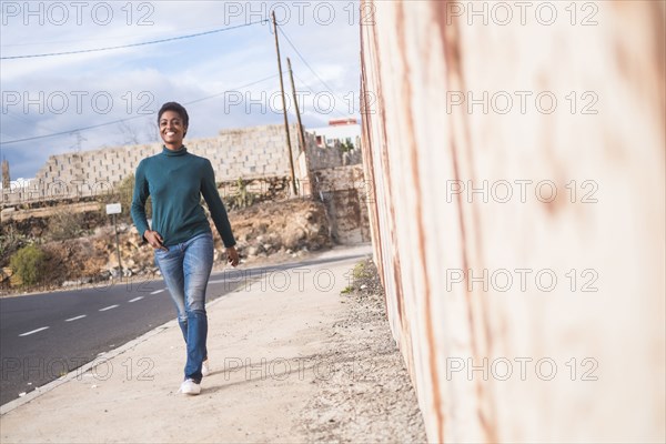 African American woman walking on urban sidewalk