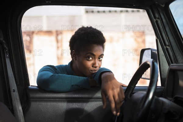 African American woman leaning on car window