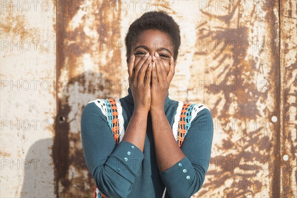 Laughing African American woman with head in hands