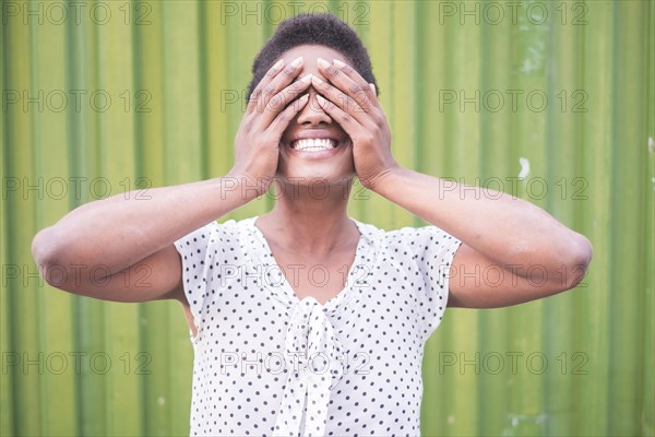 Smiling African American woman covering eyes