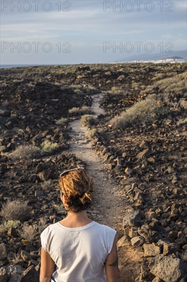 Caucasian woman standing on trail through rocks