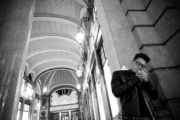 Caucasian man leaning in wall lighting cigarette