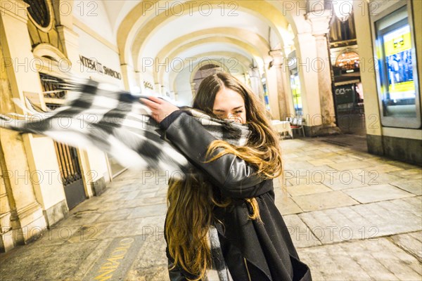 Caucasian couple tossing scarf in lobby