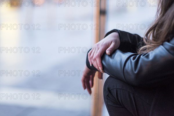 Midsection of Caucasian woman sitting outdoors