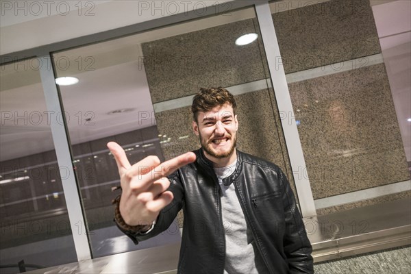 Grinning Caucasian man making obscene gesture with finger