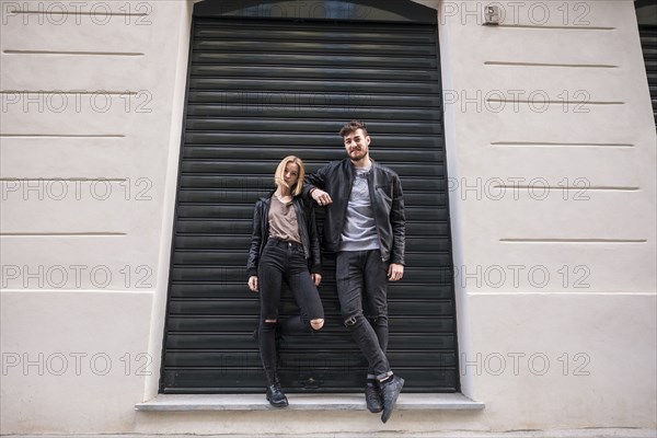 Caucasian couple leaning on doorway gate