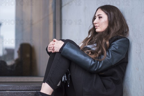 Pensive Caucasian woman sitting on staircase