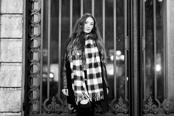 Portrait of serious Caucasian woman standing near gate