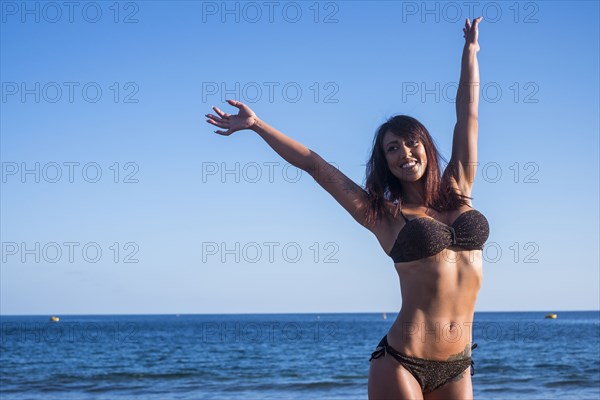 Caucasian woman celebrating on beach