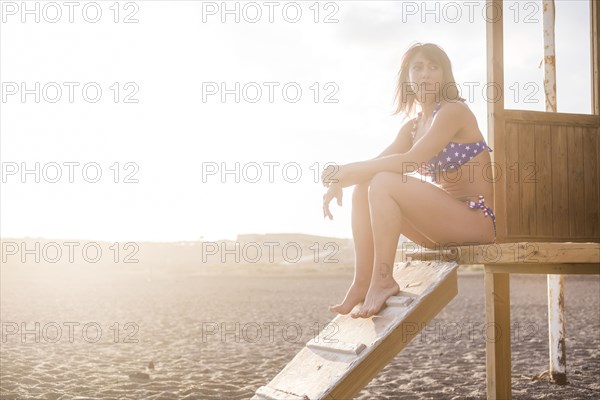 Caucasian woman sitting on cabana at beach