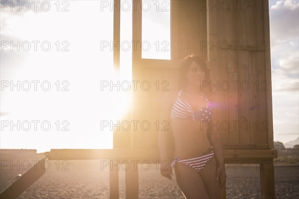 Caucasian woman leaning on cabana on sunny beach