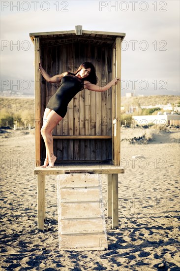 Caucasian woman standing in cabana on beach