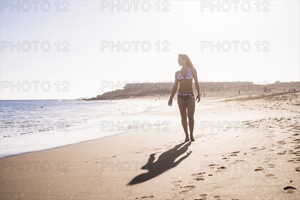 Caucasian woman walking on beach