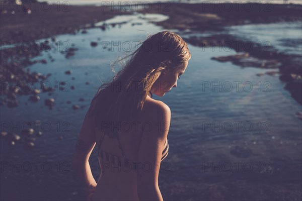 Caucasian woman looking down on beach