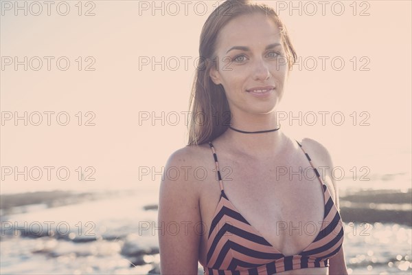 Smiling Caucasian woman wearing bikini on beach