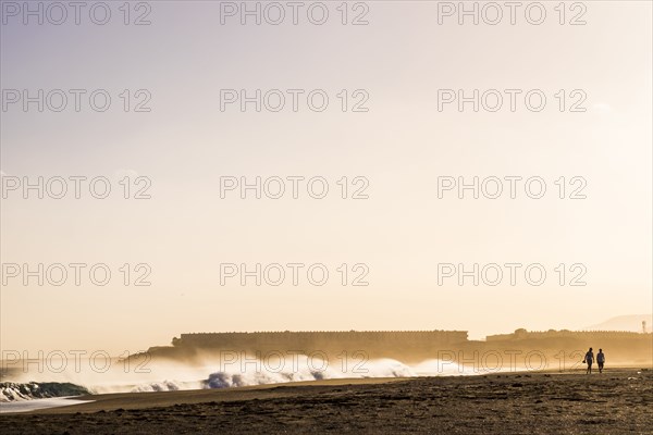 Distant people walking on beach