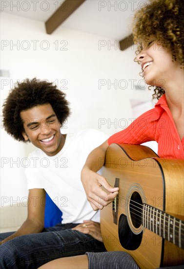 Man listening to girlfriend play guitar