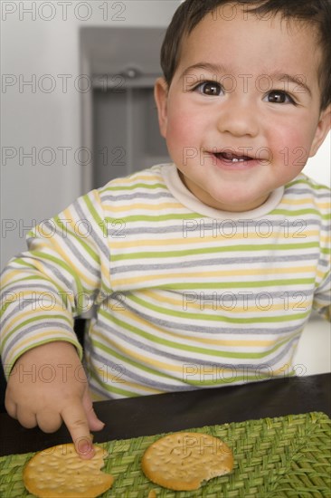 Hispanic baby boy eating crackers