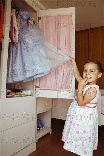 Hispanic girl taking costume from closet